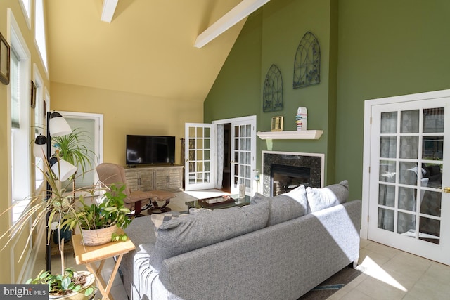 living room featuring tile patterned flooring, high vaulted ceiling, a premium fireplace, and a wealth of natural light