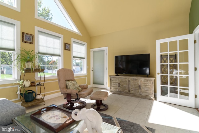 living room with light tile patterned floors and high vaulted ceiling