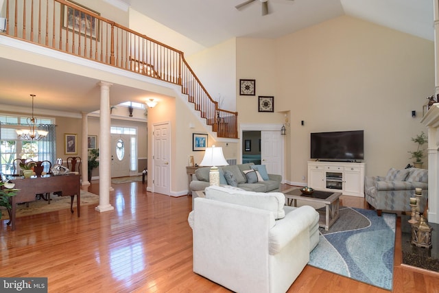 living room featuring high vaulted ceiling and light hardwood / wood-style flooring