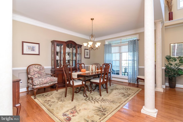 dining room with decorative columns, crown molding, a chandelier, and light wood-type flooring