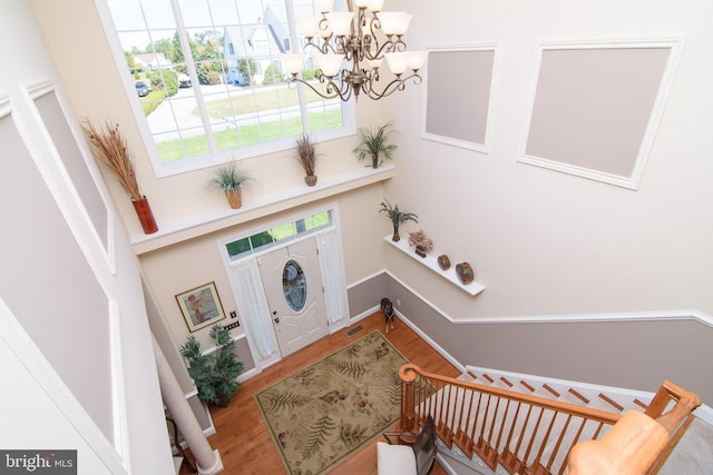 foyer entrance with a notable chandelier and wood-type flooring