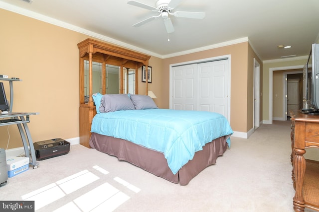 carpeted bedroom featuring ceiling fan, a closet, and ornamental molding