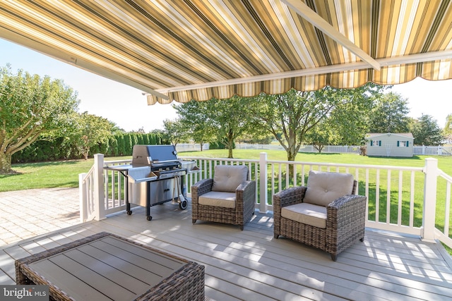 wooden terrace featuring a lawn and grilling area