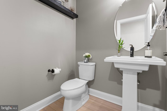 bathroom with hardwood / wood-style floors and toilet