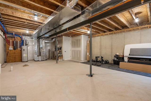 basement featuring heating unit and electric water heater