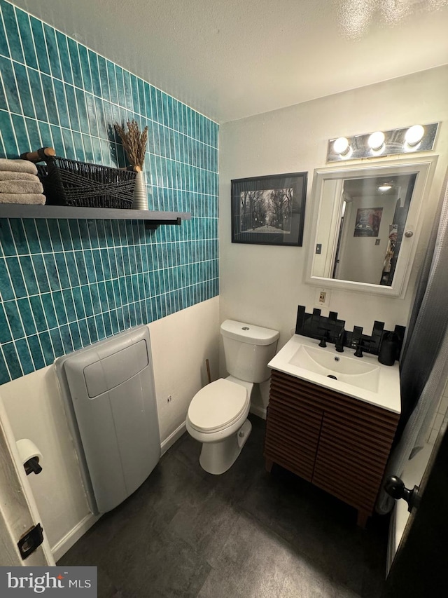 bathroom featuring vanity, tile walls, and toilet