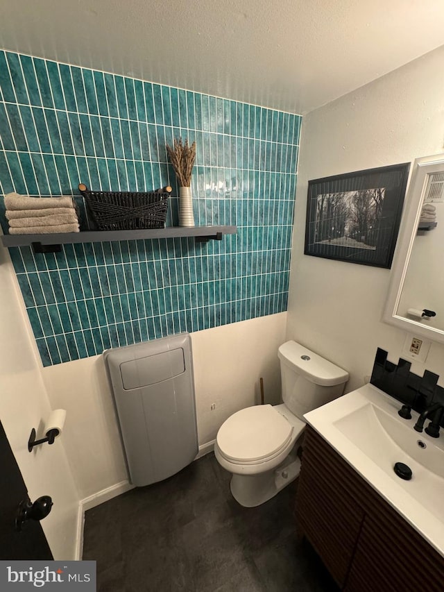 bathroom featuring concrete floors, vanity, and toilet