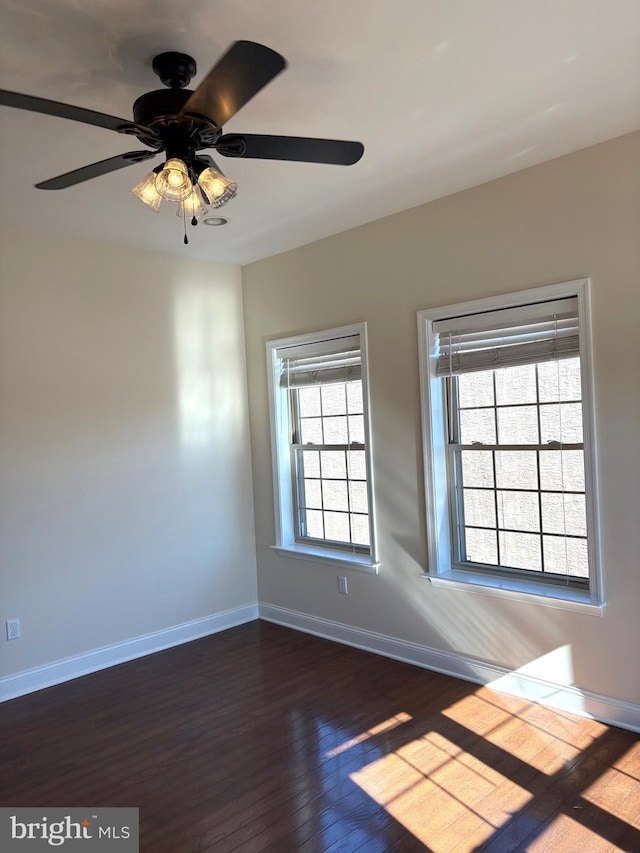 spare room featuring dark wood-type flooring and ceiling fan