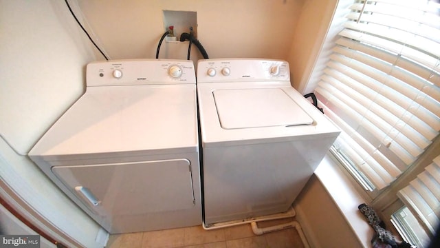 clothes washing area with tile patterned floors and separate washer and dryer