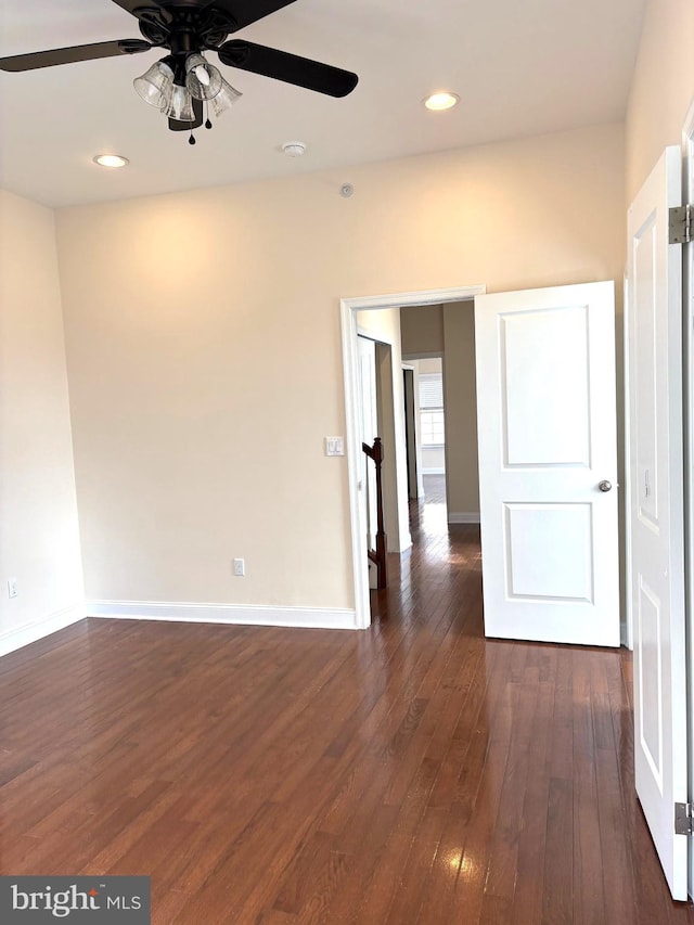 unfurnished room featuring dark wood-type flooring and ceiling fan