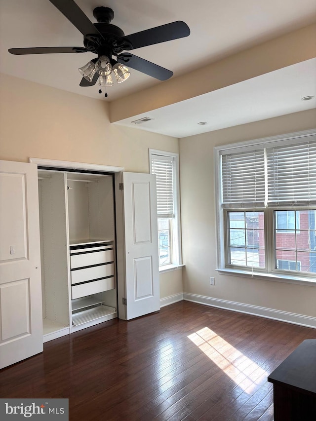 unfurnished bedroom featuring dark hardwood / wood-style floors, a closet, and ceiling fan