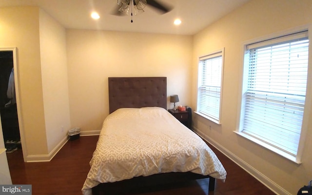 bedroom with ceiling fan, a skylight, and dark hardwood / wood-style flooring