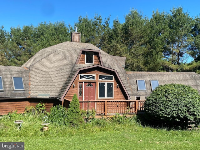 view of front of house with a deck and a front lawn