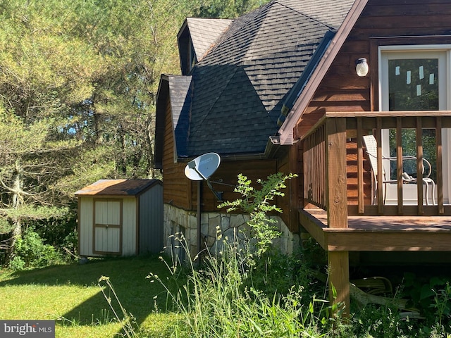 view of property exterior featuring a deck, a yard, and a shed