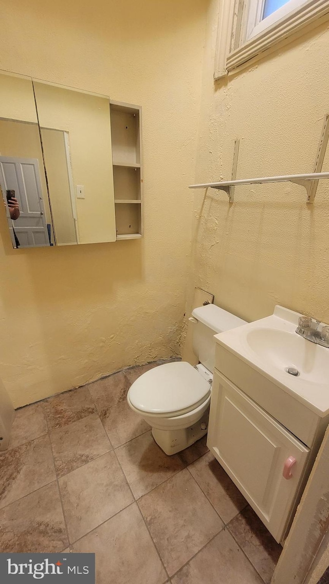 bathroom featuring tile patterned flooring, vanity, and toilet