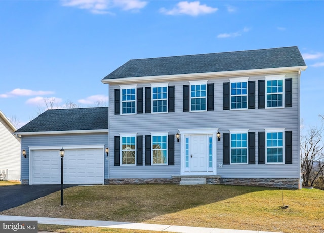 colonial inspired home with a garage and a front lawn