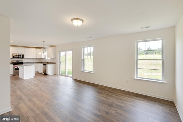 unfurnished living room featuring hardwood / wood-style floors and a wealth of natural light