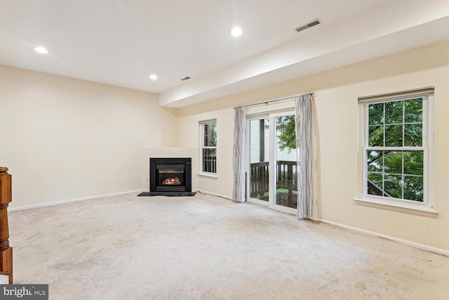 unfurnished living room with a wealth of natural light and carpet