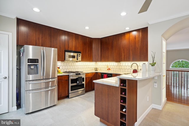 kitchen with tasteful backsplash, sink, kitchen peninsula, appliances with stainless steel finishes, and ornamental molding