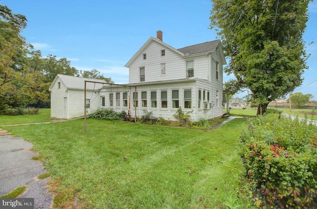 rear view of property featuring a yard