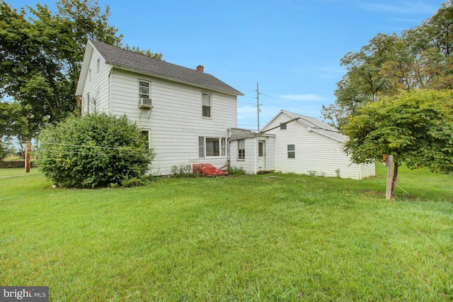 rear view of house with a lawn and cooling unit