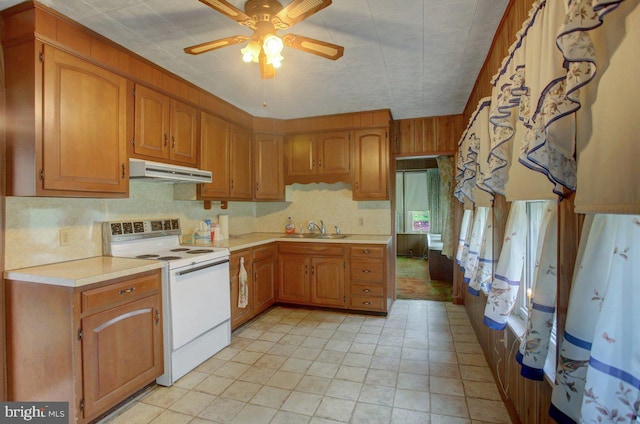 kitchen featuring ceiling fan, light tile patterned floors, sink, and electric range