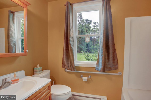 bathroom featuring a baseboard radiator, plenty of natural light, vanity, and toilet