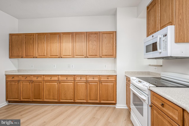 kitchen featuring white appliances and light hardwood / wood-style flooring