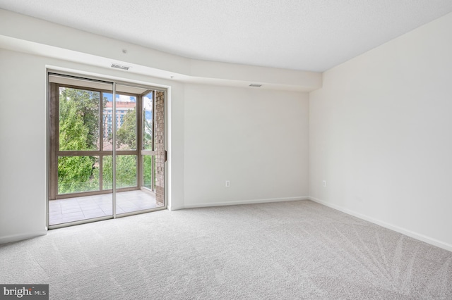 carpeted empty room featuring a textured ceiling