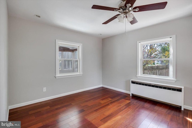 spare room featuring a baseboard radiator, ceiling fan, dark hardwood / wood-style floors, and radiator