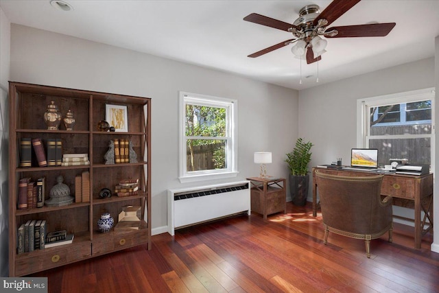 office featuring radiator heating unit, ceiling fan, and dark hardwood / wood-style flooring