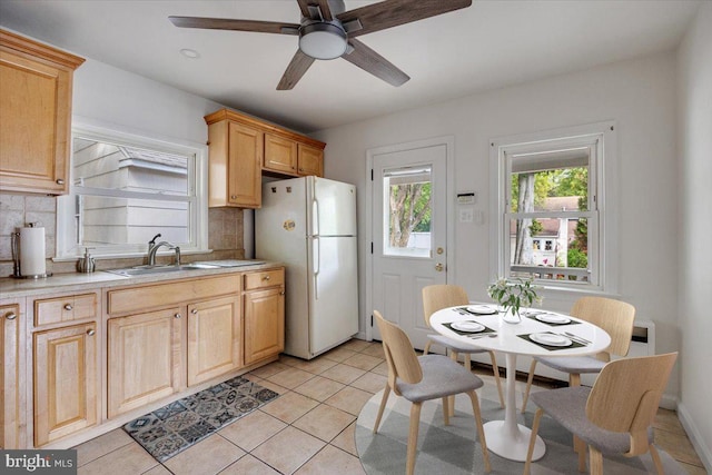 kitchen featuring decorative backsplash, sink, white refrigerator, and light brown cabinets