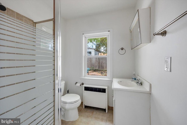 bathroom featuring walk in shower, radiator, toilet, vanity, and tile patterned flooring