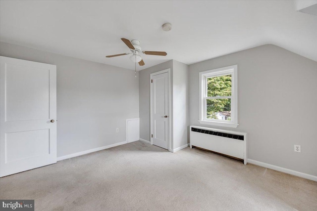 bonus room with vaulted ceiling, light carpet, and radiator