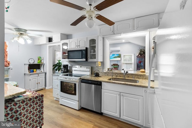 kitchen with ceiling fan, white cabinets, sink, light hardwood / wood-style flooring, and appliances with stainless steel finishes