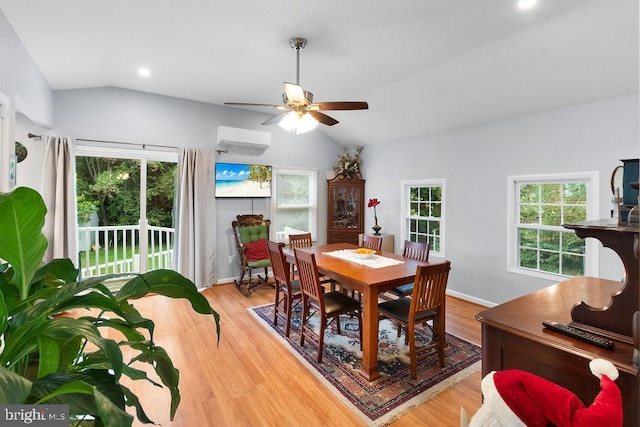 dining area with lofted ceiling, ceiling fan, a wall unit AC, and light hardwood / wood-style flooring