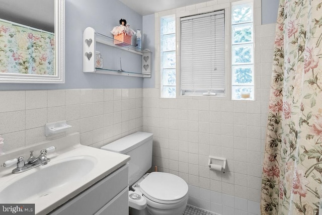 bathroom with tile walls, a shower with curtain, vanity, and toilet