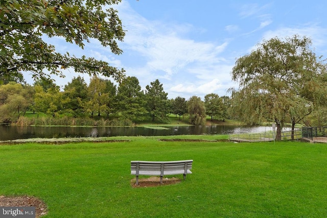 view of community featuring a lawn and a water view