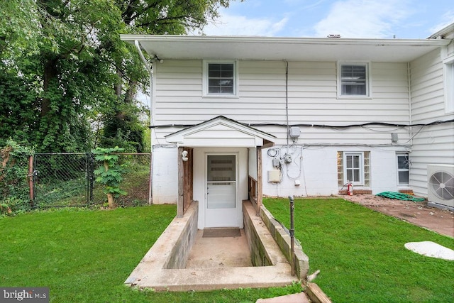 view of front of house with ac unit and a front lawn