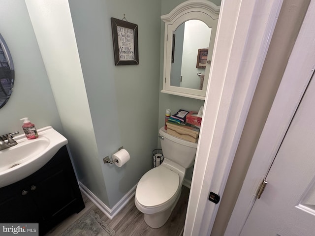 bathroom featuring hardwood / wood-style flooring, vanity, and toilet