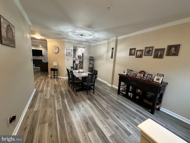 dining room with crown molding, a notable chandelier, and hardwood / wood-style flooring