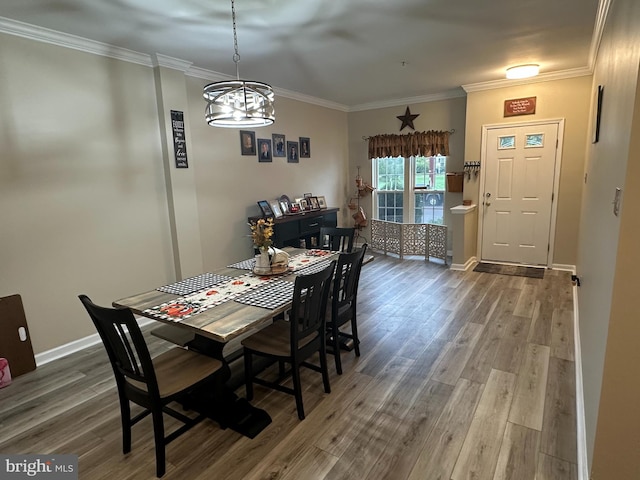 dining space featuring hardwood / wood-style floors, ornamental molding, and a notable chandelier