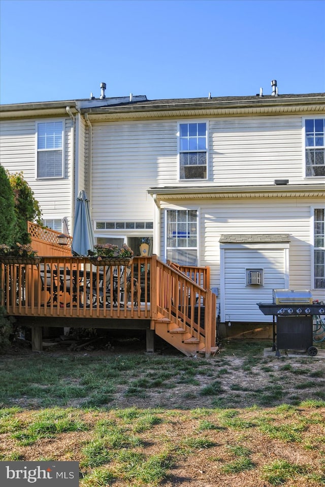 back of house with a deck and a yard