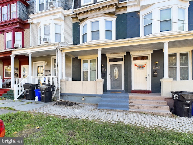 view of front of property with cooling unit and a porch