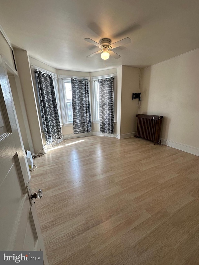 unfurnished living room with light hardwood / wood-style flooring and ceiling fan