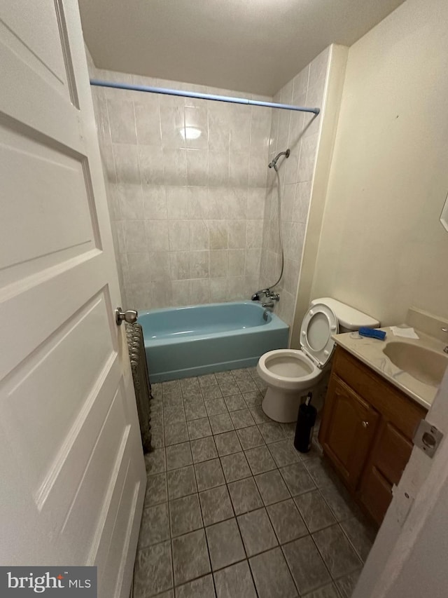 full bathroom with vanity, tiled shower / bath combo, toilet, and tile patterned flooring