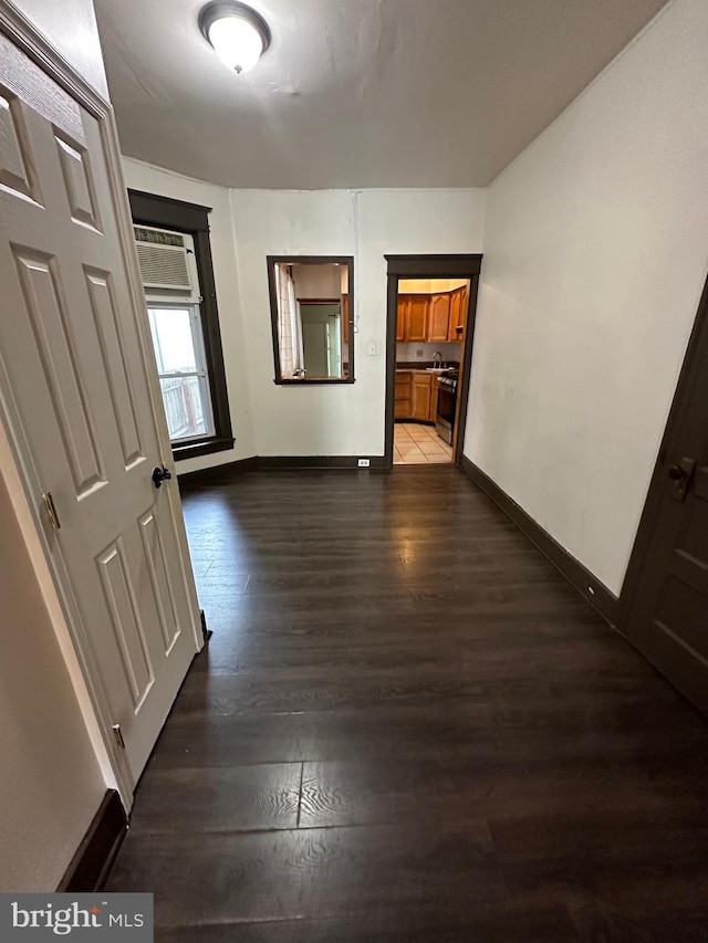 hall featuring dark wood-type flooring and a wall unit AC