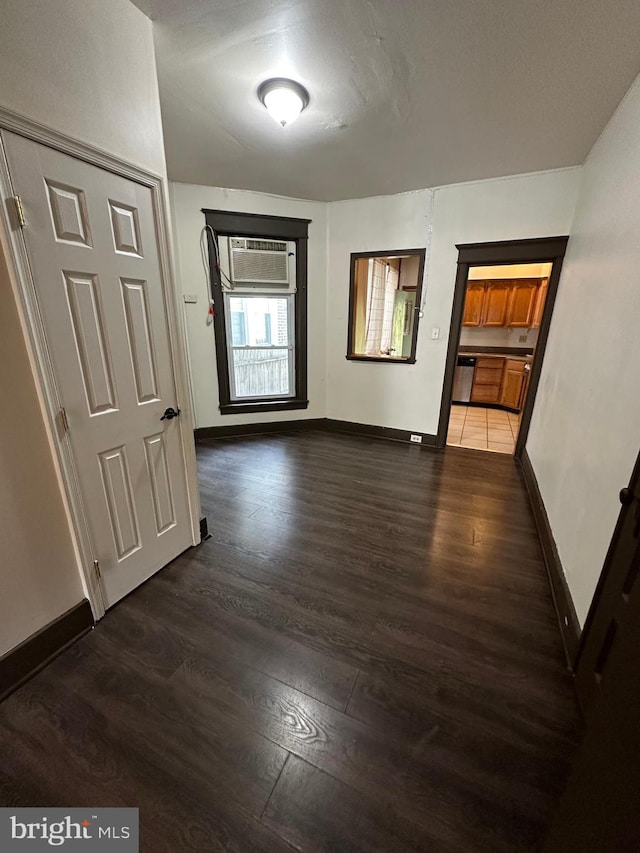 hall featuring a wall unit AC and dark wood-type flooring