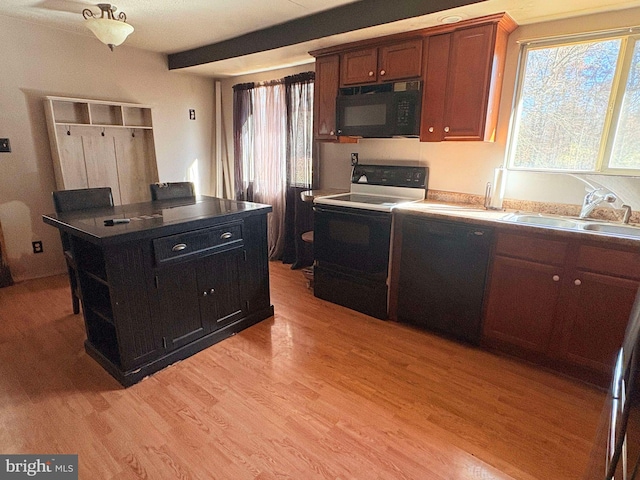 kitchen with black appliances, light wood-type flooring, and sink