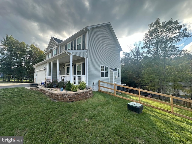 view of side of property featuring a lawn and covered porch